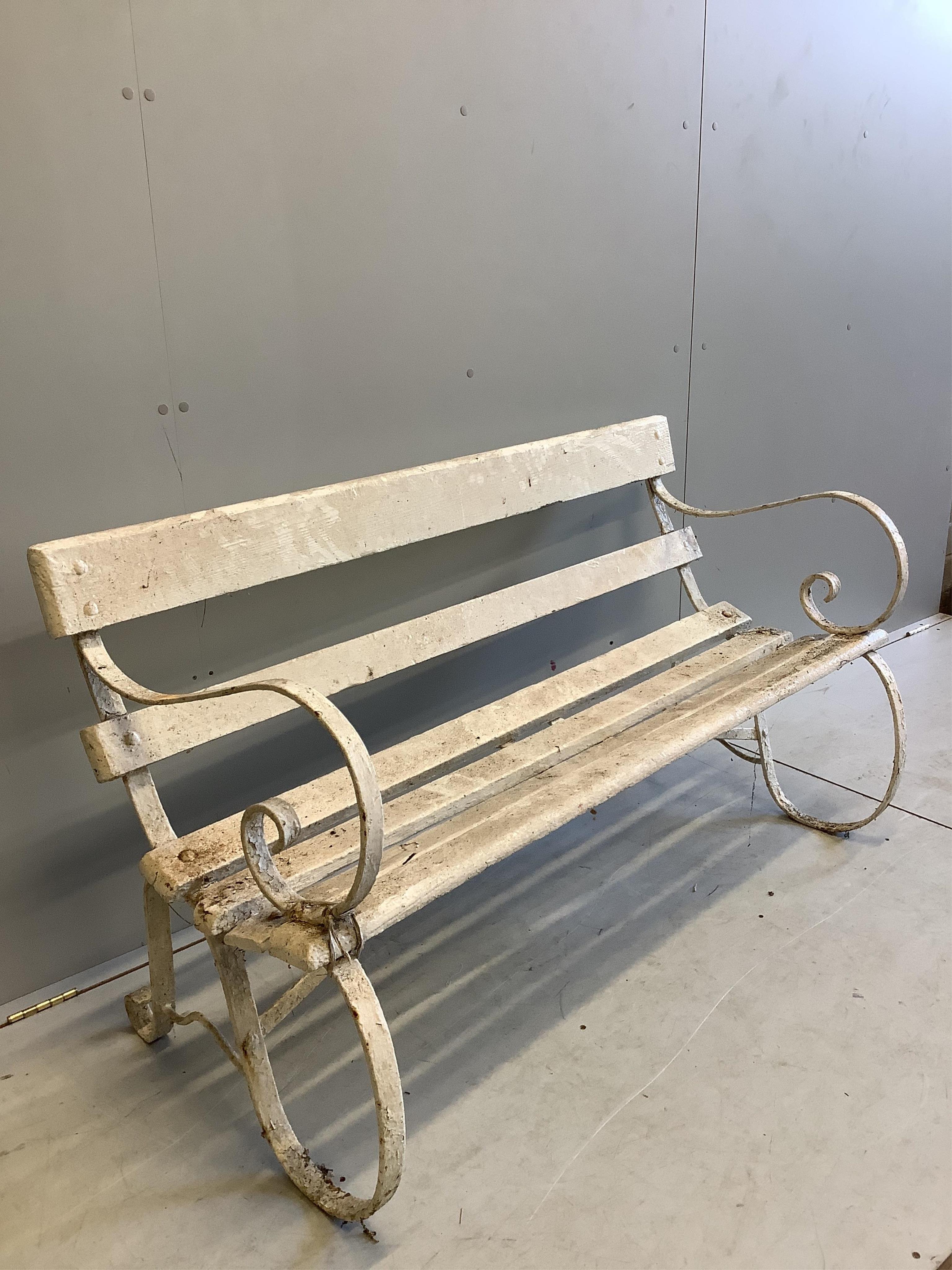 A white painted slatted wood garden bench with wrought iron ends, width 137cm, depth 63cm, height 78cm. Condition - poor to fair